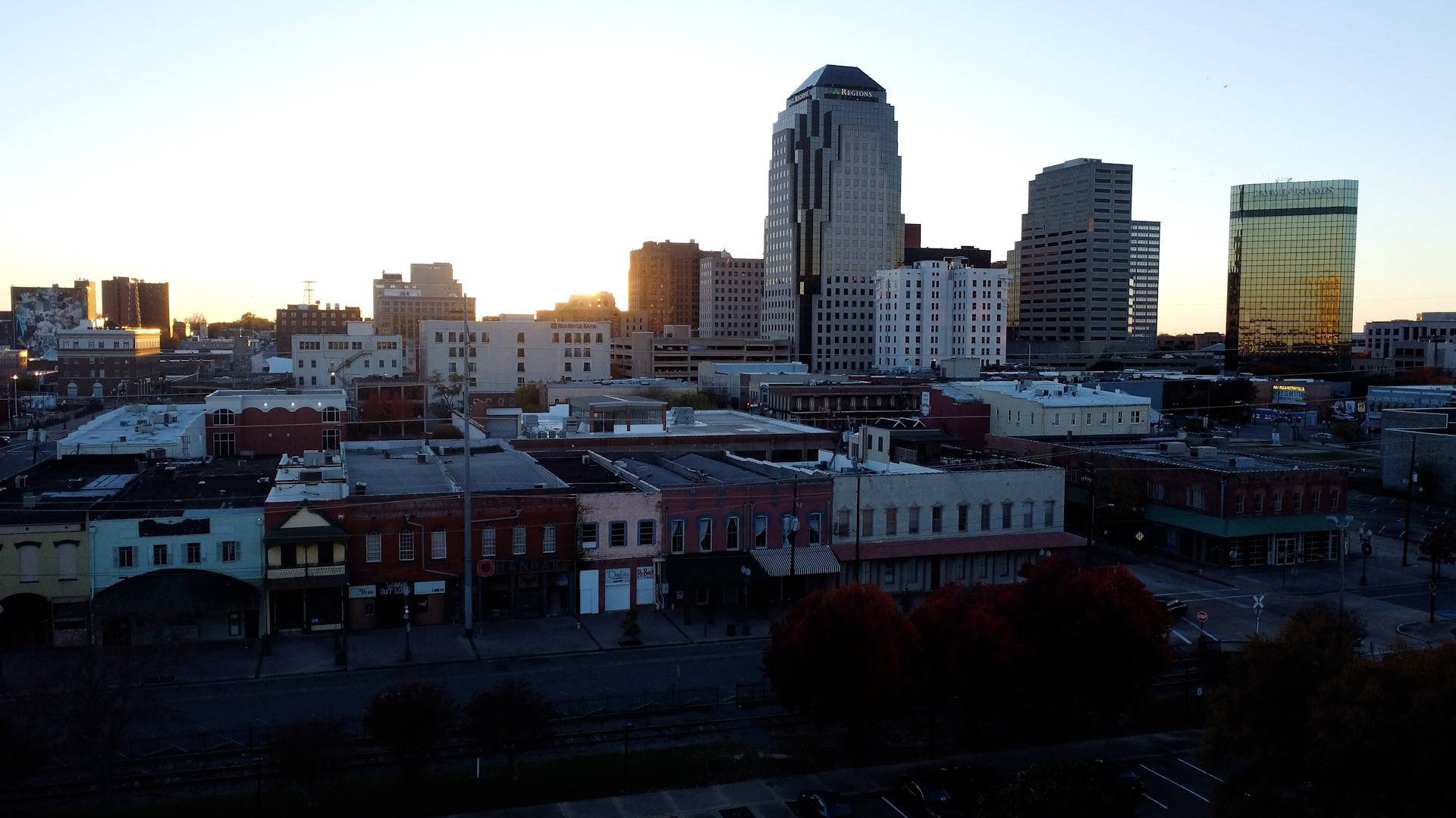 Aerial view of the Downtown Shreveport skyline lit by warm golden hour sunlight.